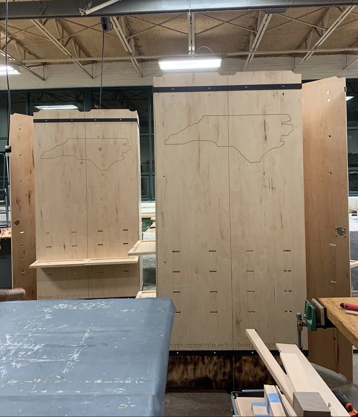 Plywood booth panels mid-fabrication with NC state outline