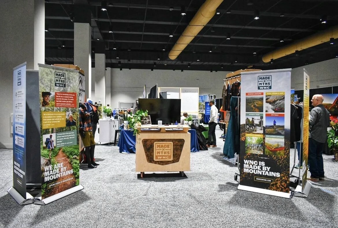 NC OPPS booth at Outdoor Retailer with MADE x MTNS WNC banners